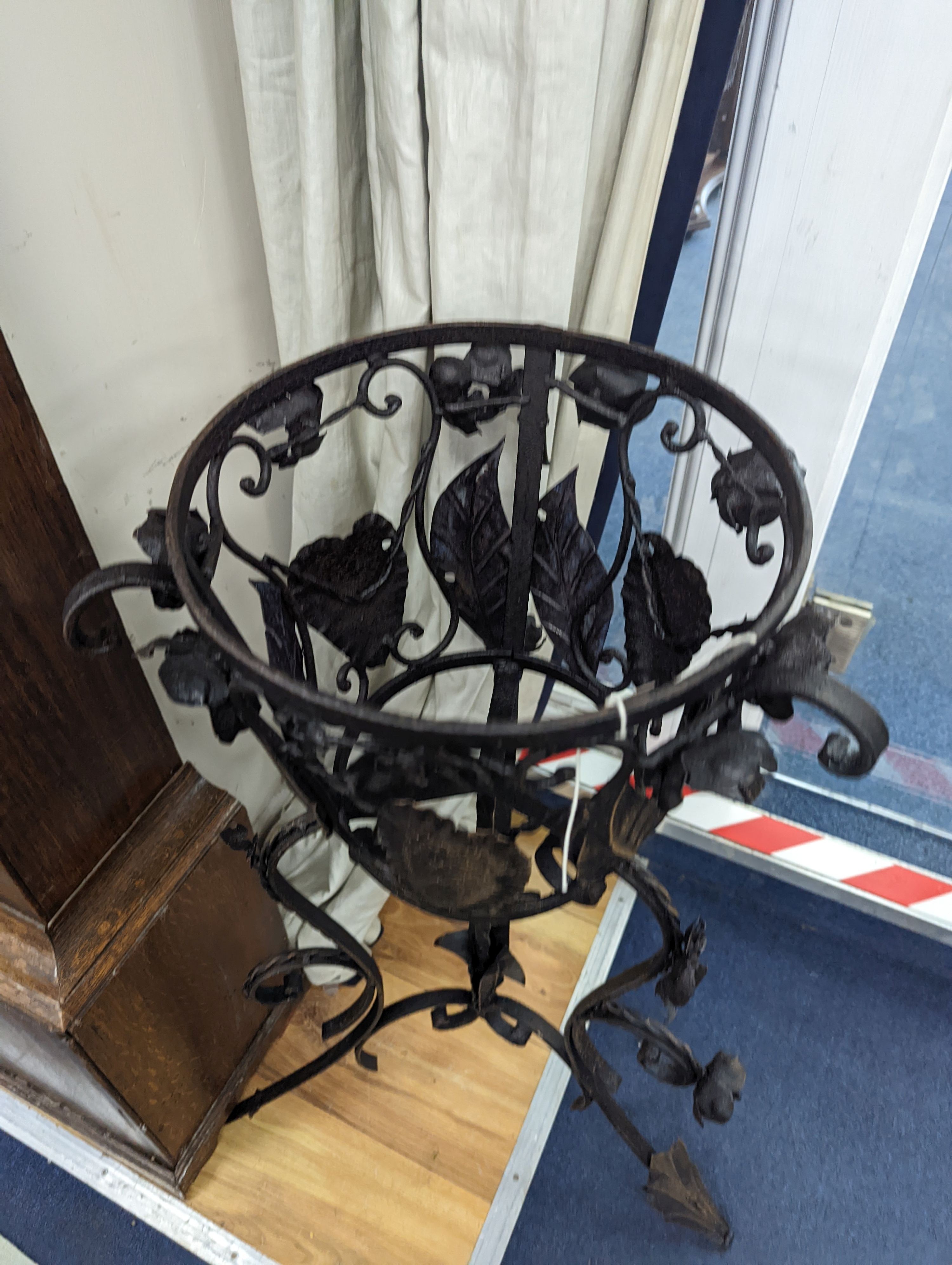 A pair of wrought iron garden planters, no liners, height 81cm
